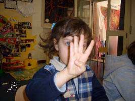 Il bambino indica il numero con le dita